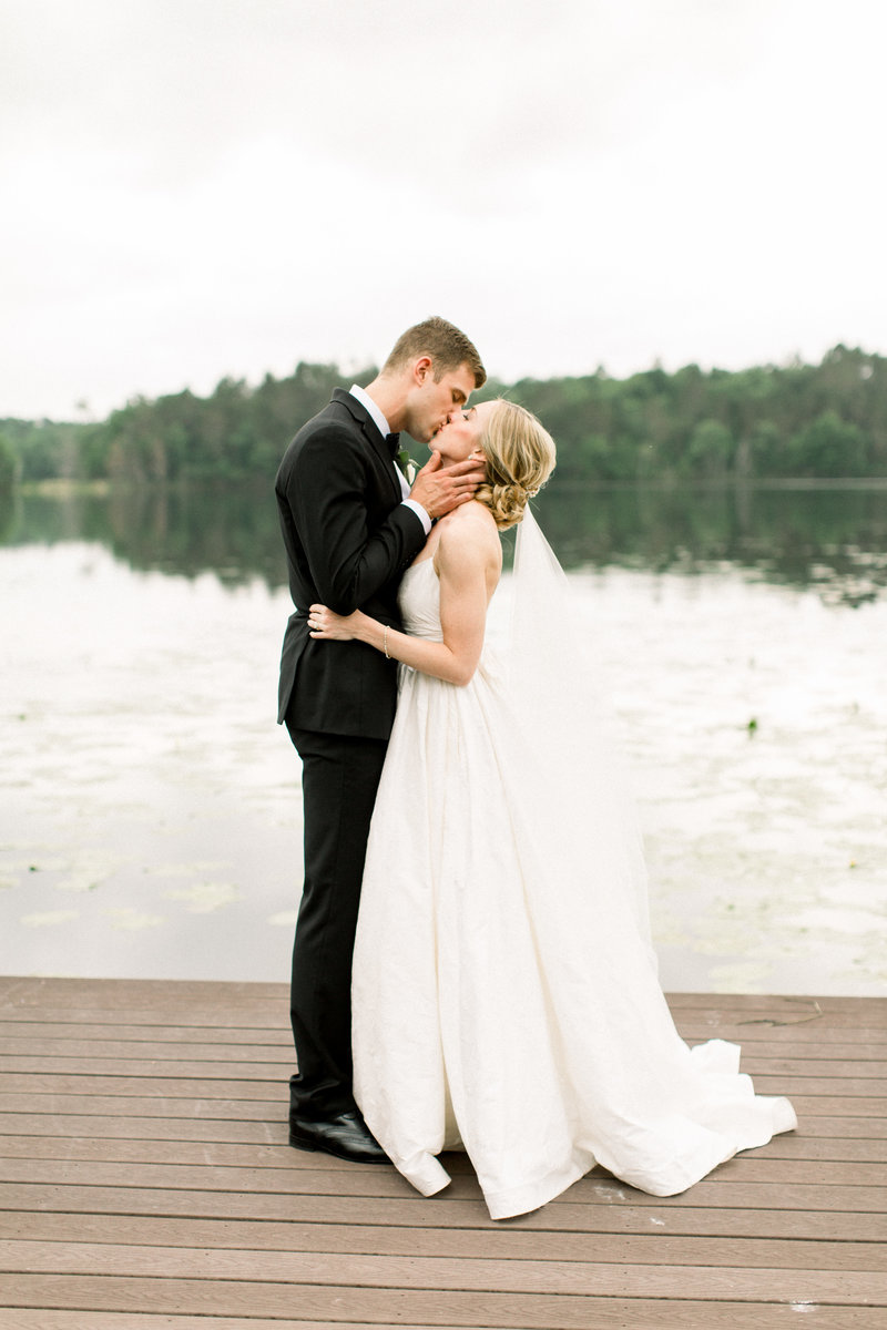 Bride and Groom kissing by lake
