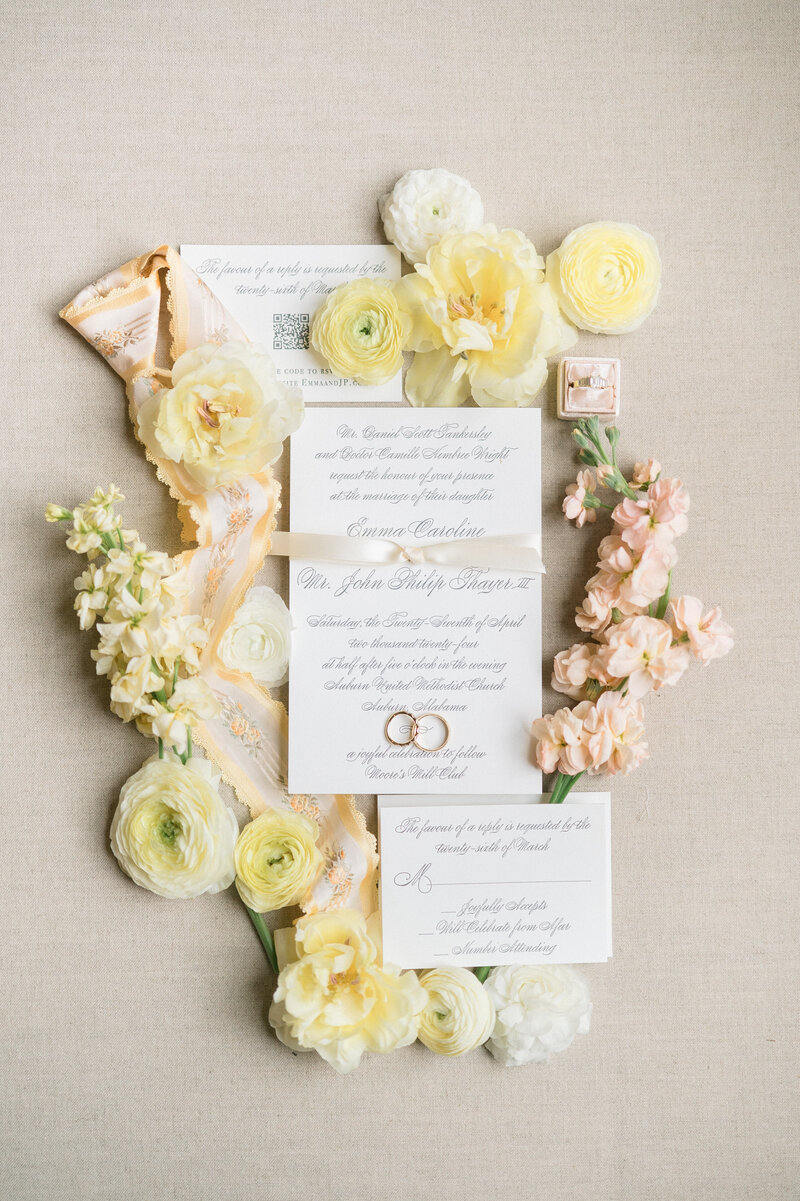 Yellow flowers around wedding invitation with ribbon
