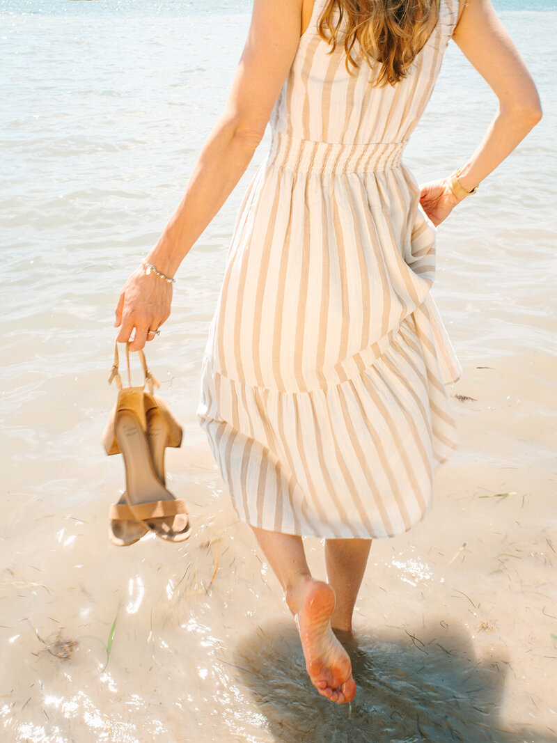Kilee in a striped dress standing in the ocean
