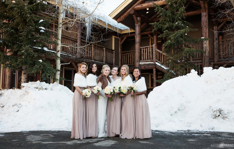A winter bride poses with her bridesmaids all wearing fur stoles at The Lodge at Breckenridge in Colorado