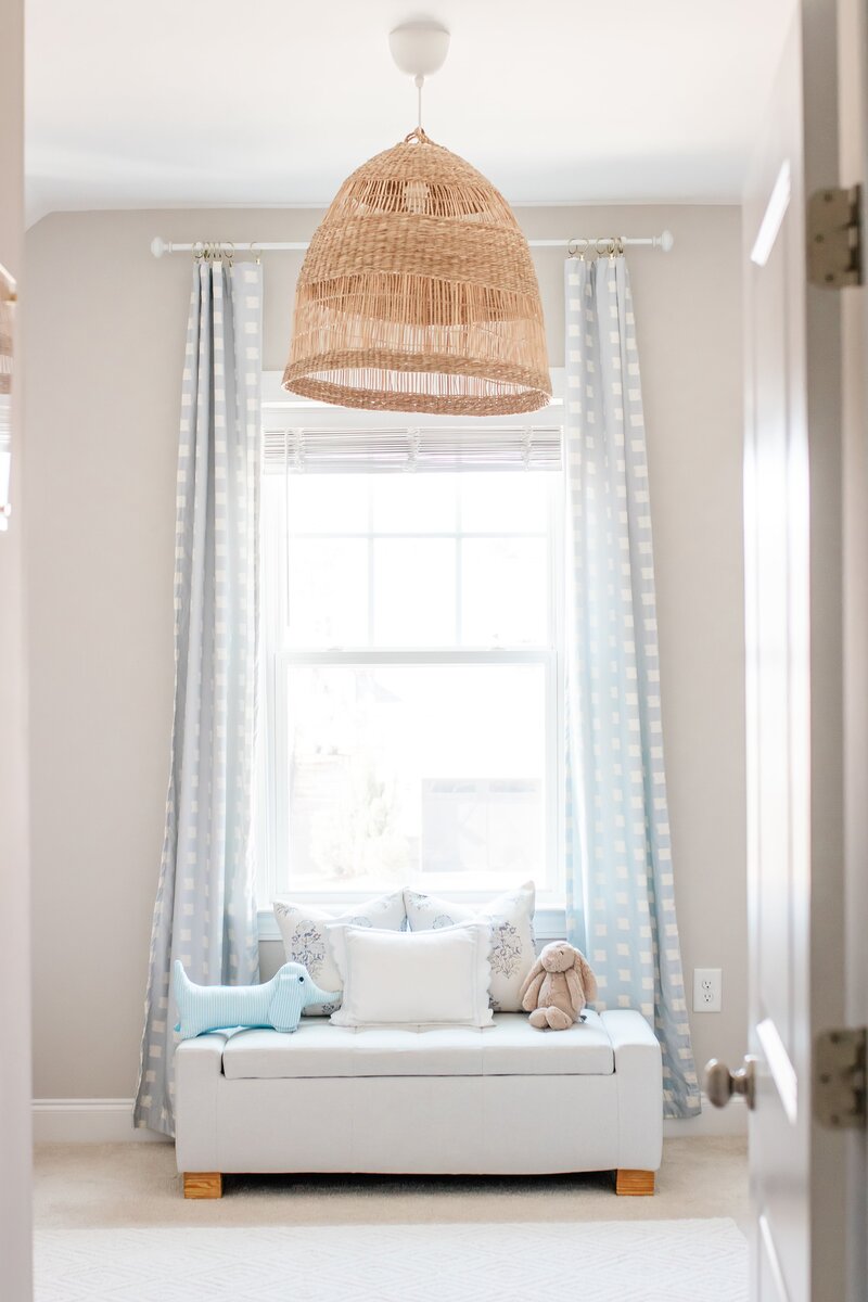 Cozy, styled room with a window, chair, and woven light fixture.