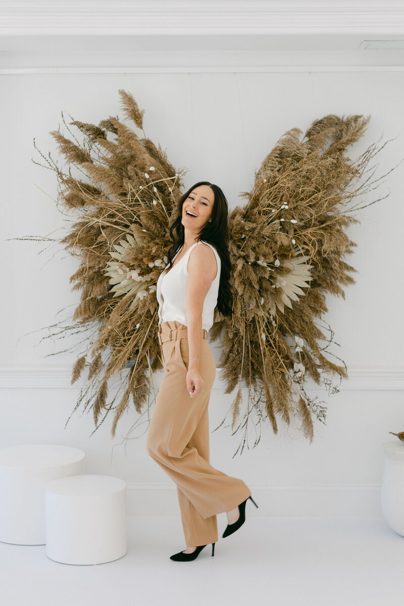 kat laughing in front of butterfly decoration on wall