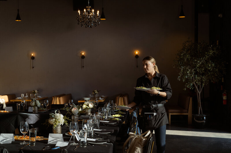 Event photography moment as waitstaff prepares dining scene for a private event at Stirr restaurant in Deep Ellum.