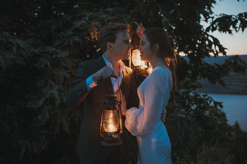 Bride and groom holding lanterns in the dark