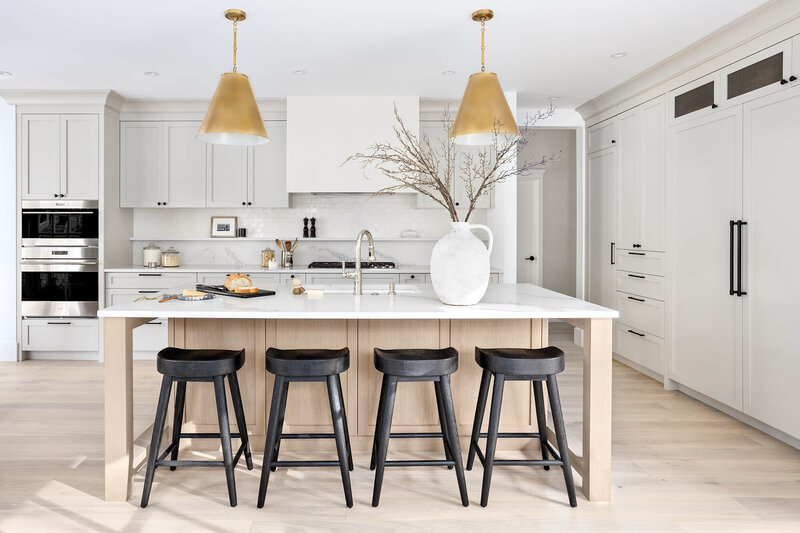 Marguerite Project, a grey dining room with a wooden oval table, green chairs, and lots  of windows