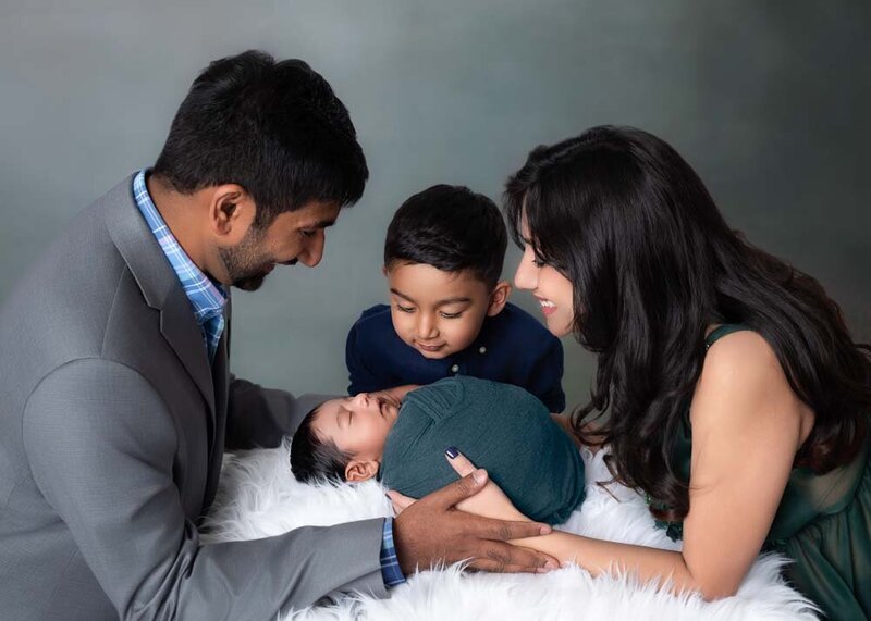 family-looking-at-newborn-parents-sibling