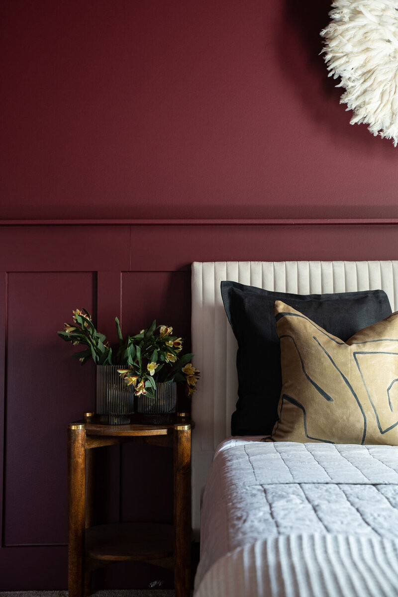 bedroom with dark red walls and gold accents