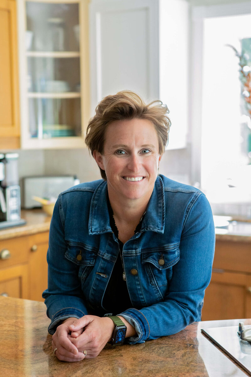 realtor leans on counter in kitchen