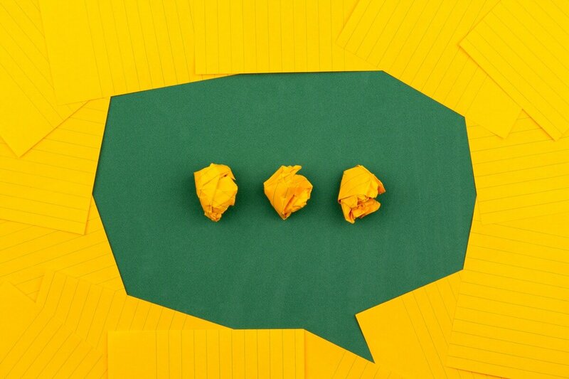 green chat bubble on yellow paper for SEO help conversation