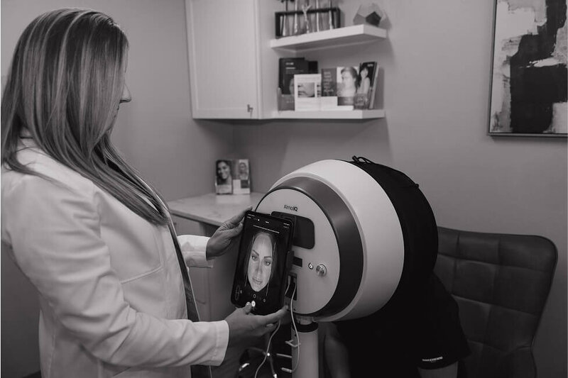 Kylee using the Alma IQ machine to analyze a patients skin condition before a treatment.