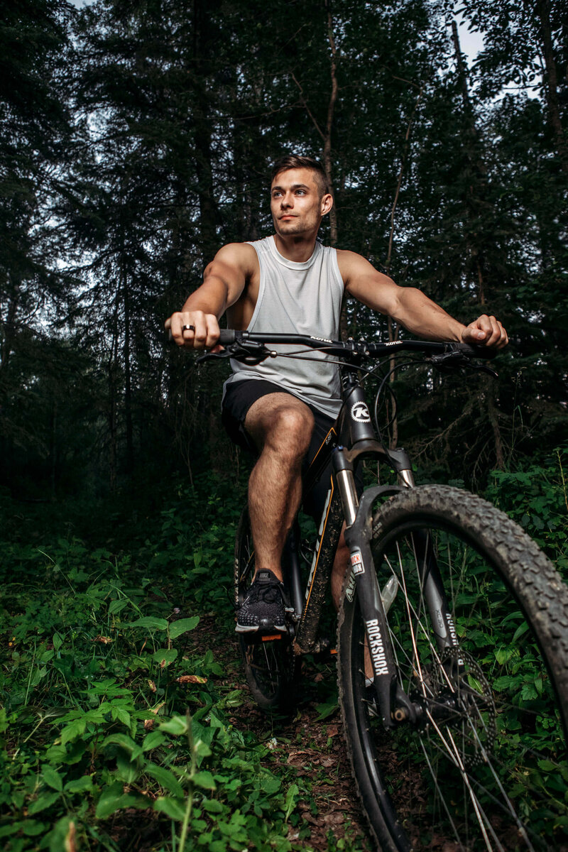 muscular man on mountain bike in forest
