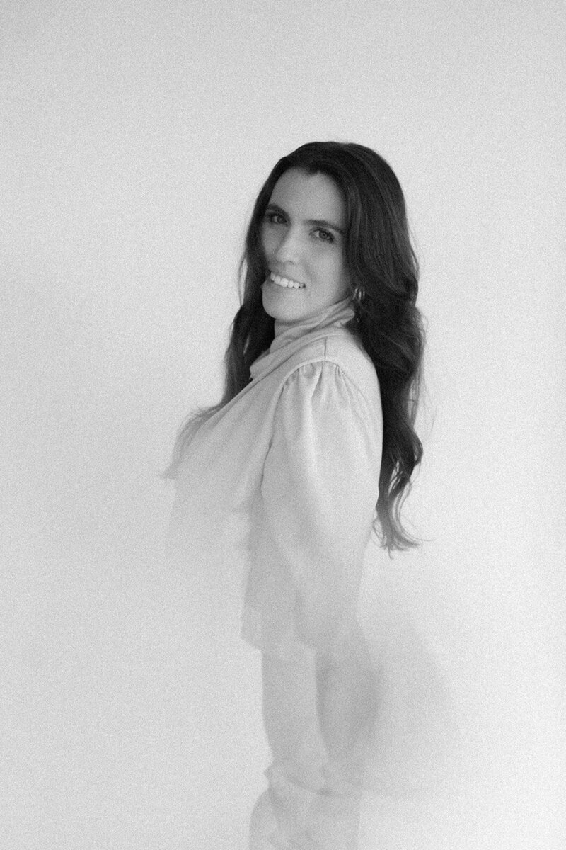 Seattle wedding photographer Natalie Jayne smiles in a soft black and white portrait.