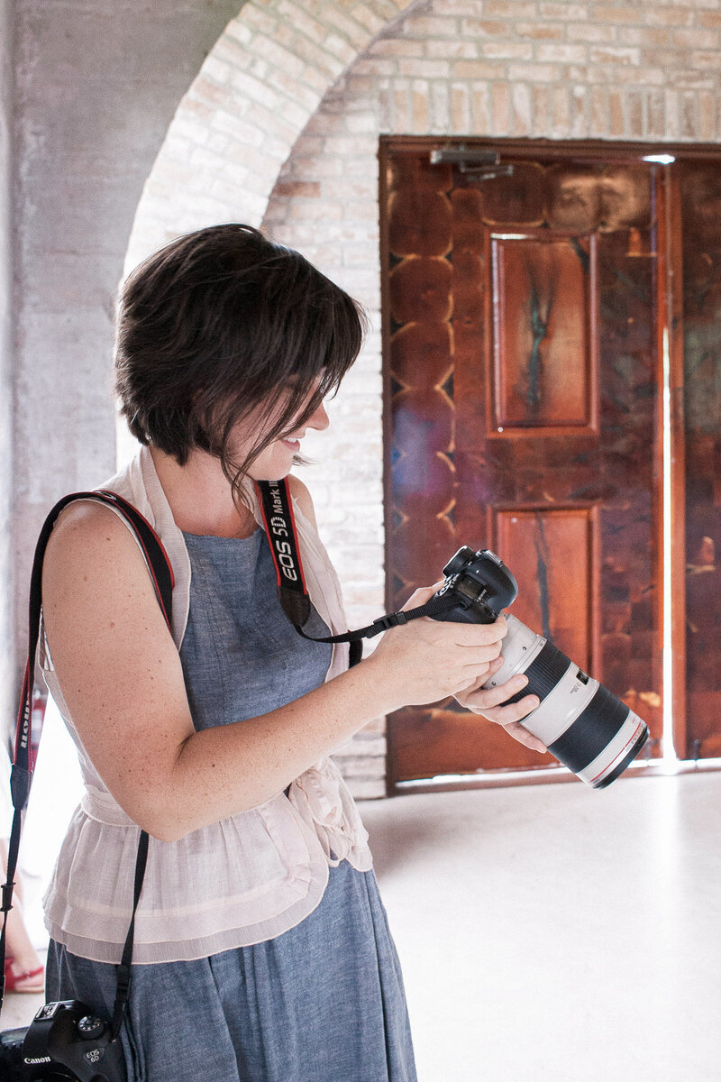 Stephanie, your Denver wedding photographer,  looking at images on her camera during a wedding