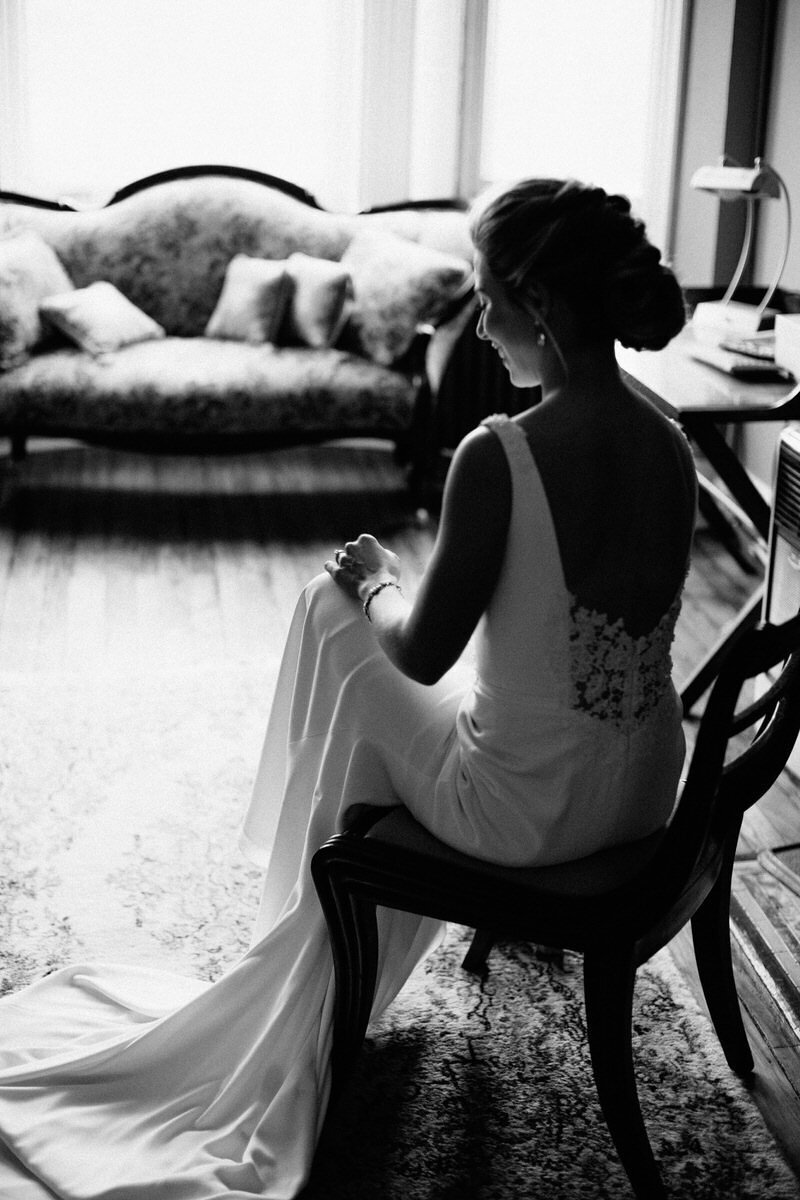 Black and white bride sitting down facing away from camera