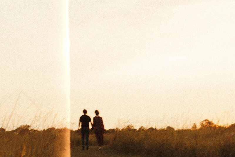 Couple walking in a field at golden hour in Afton State Park MN