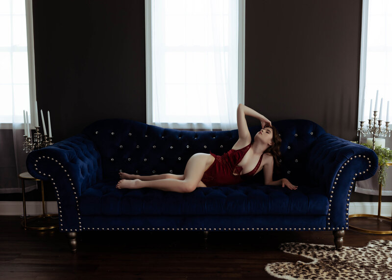 woman arching on blue couch in red lingerie elkridge
