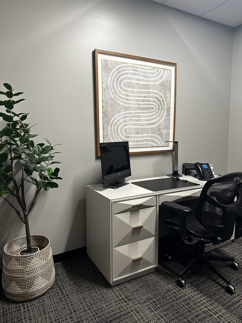Modern funky white desk next to a plant