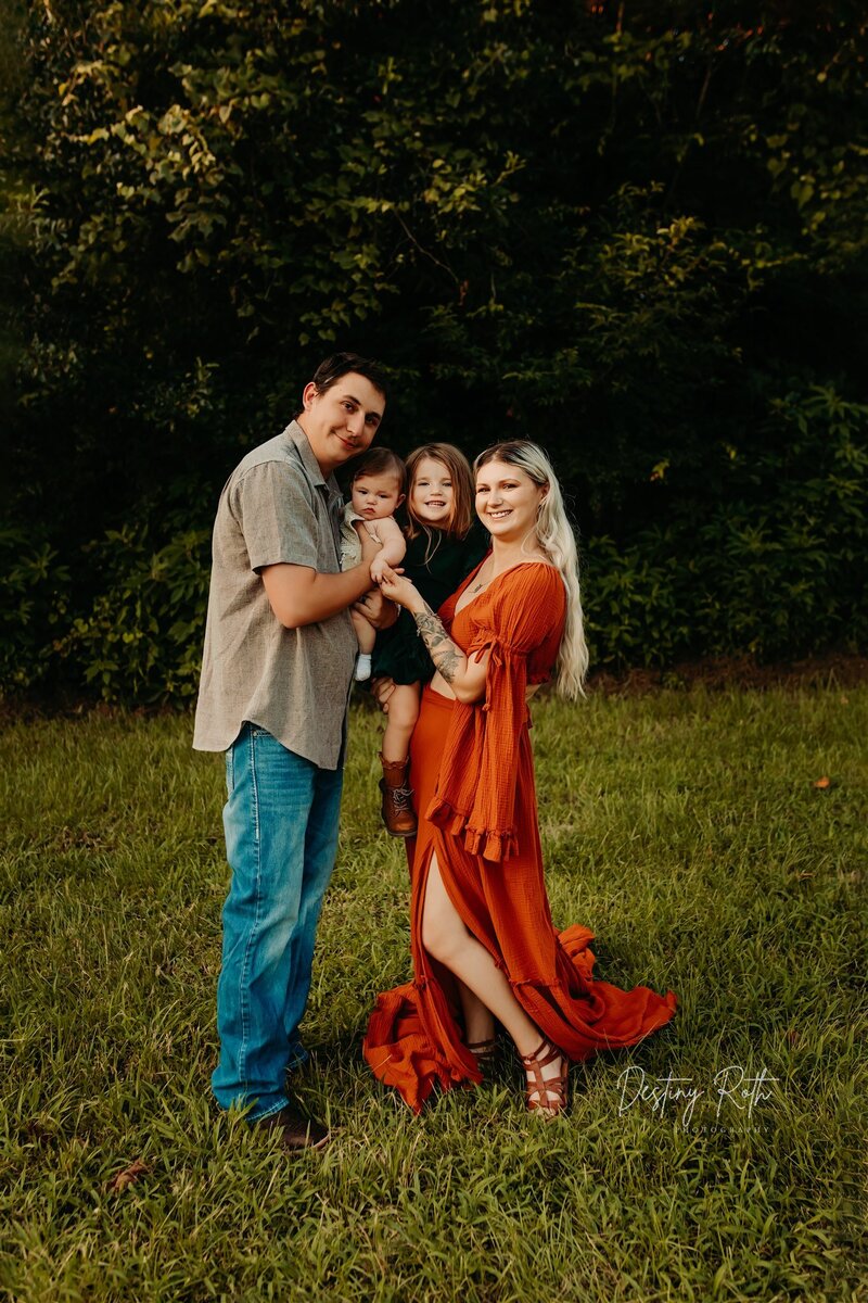 Destiny Roth, Cleveland TX boudoir and portrait photographer, smiling with her family outdoors