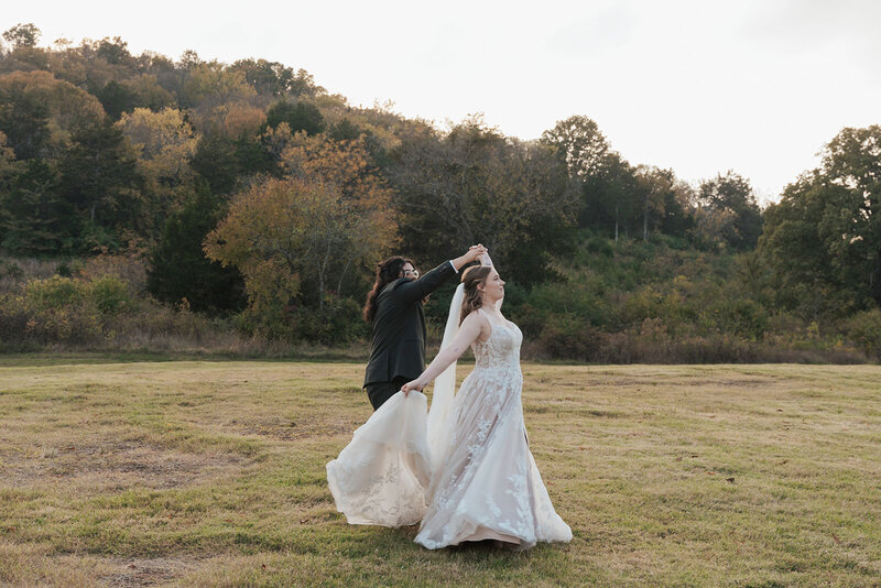 Woman twirls her new wife in the grass 