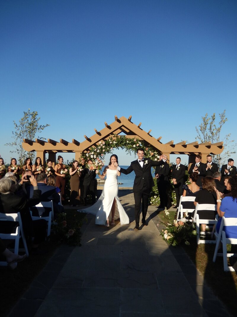 Caroline and her husband walking down the aisle after sharing their first kiss as a married couple.