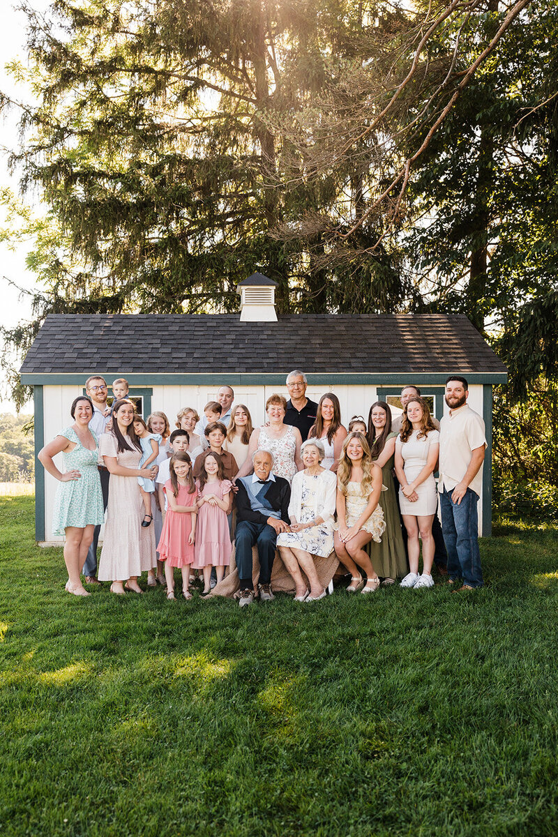 Multi-generation family photo with smiling grandparents and playful grandchildren enjoying a sunny day outdoors, captured by a talented family photographer in Pittsburgh, PA.