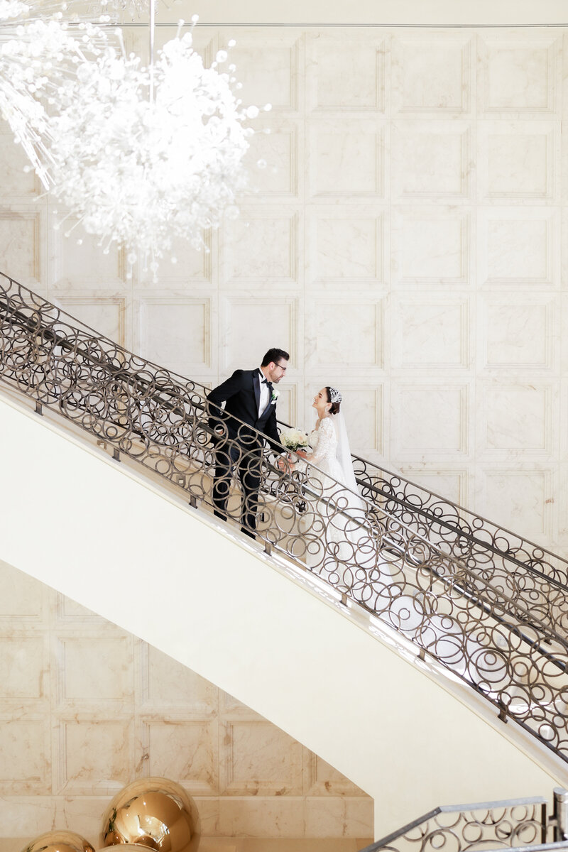 Bride and groom portrait on the grand staircase at a wedding at the four seasons Orlando by Florida wedding photographer.