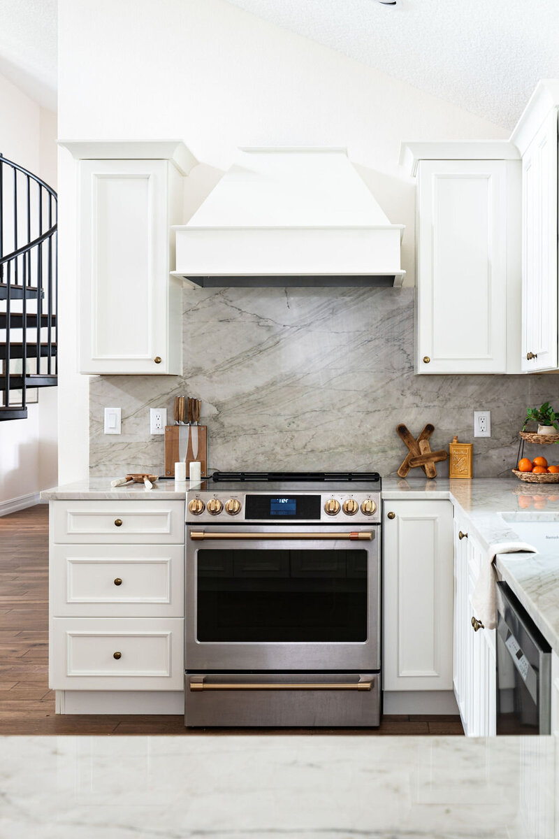 White detailed cabinetry and cristallo stone with white wainscot featured in this kitchen renovation.