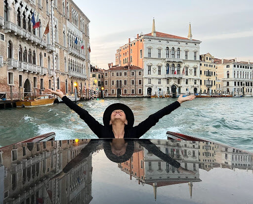 Melinda Fornero arms up to the sky with river in background
