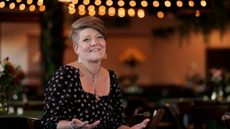 a person smiling as she talks to people 