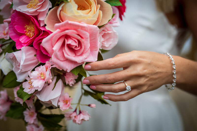 Bride holding a cascading bouquet of paper roses and cherry blossom