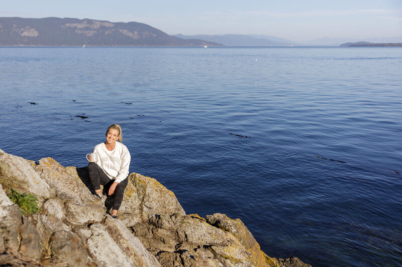 Kat, a dental hygienist and health coach, relaxing by the water to emphasize balance in health and wellness.