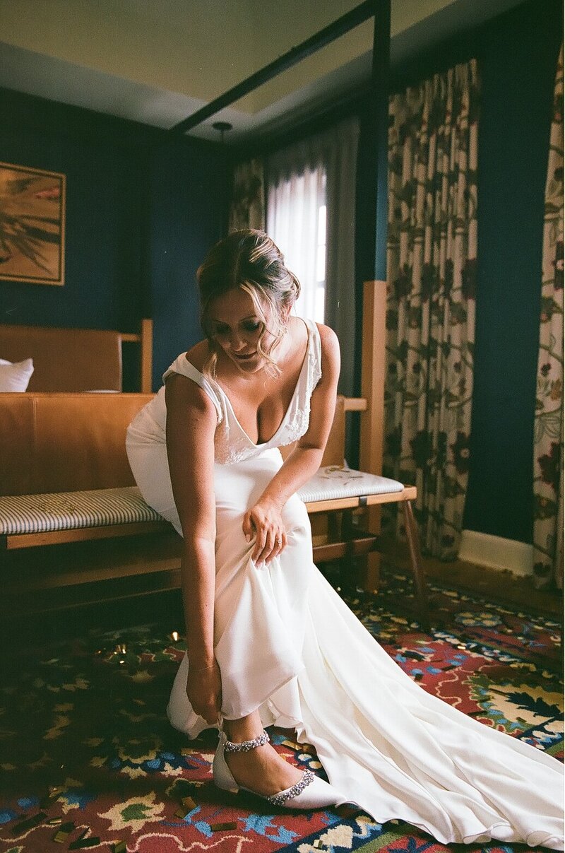 Bride putting her shoes on photo on film