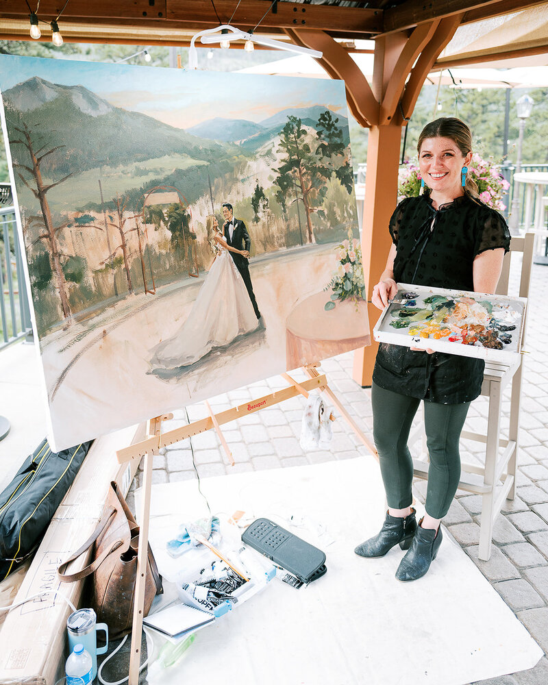 Stephanie Torregrossa Gaffney holds wedding painting with couple