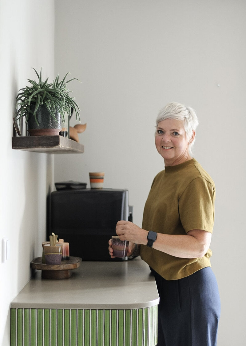 Threa van LOOSZ Interieur & Styling bij een groene koffiebar, gestyled met planten en warme details, in een lichte en moderne ruimte
