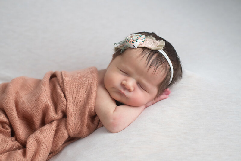 Newborn girl sleeping snuggled in blanket