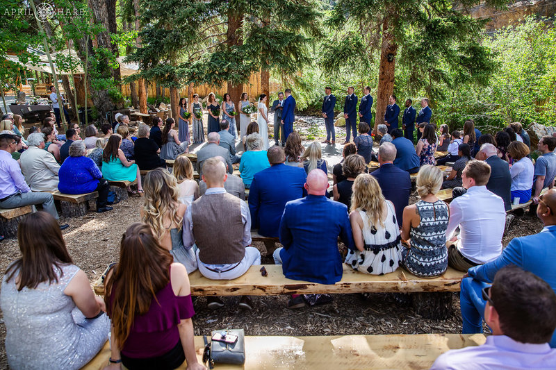 Wedding Guests sit on benches at Blackstone Rivers Ranch