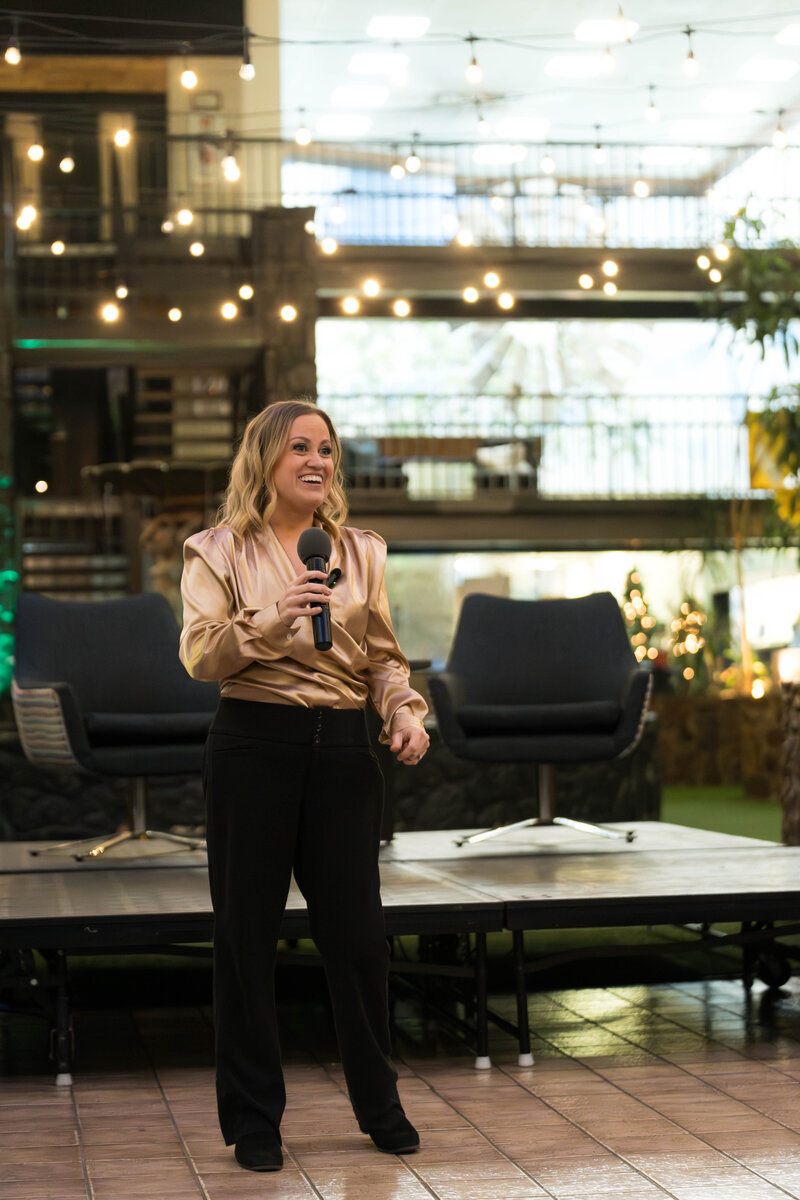 Female keynote speaker Brit Nicole presenting business transformation strategies to executive audience