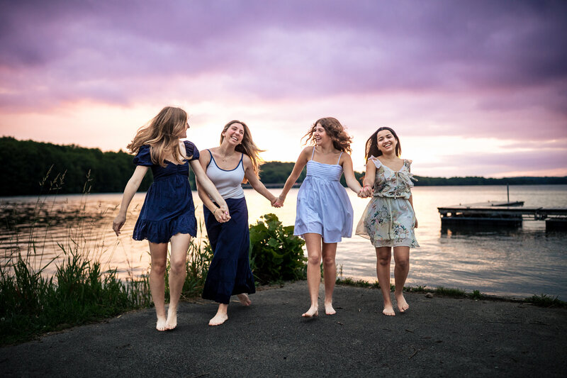 Four girls dance near the lake at Moraine state park north of the city of Pittsburgh for senior photos