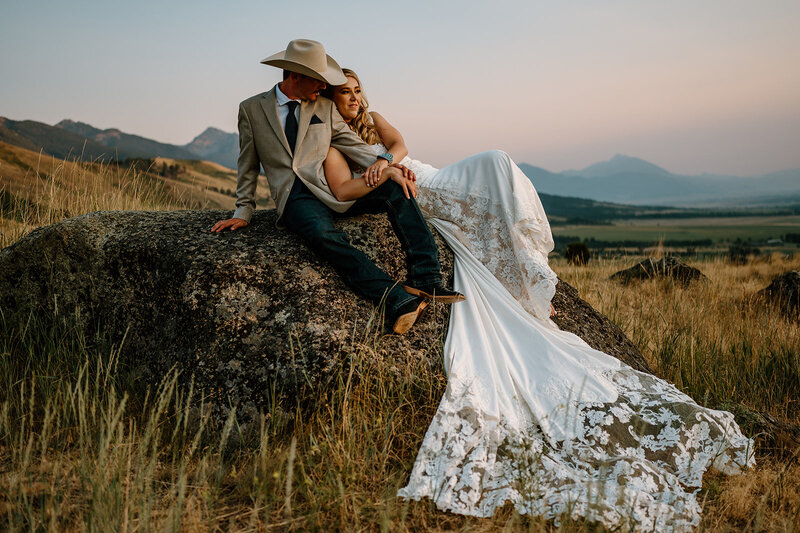 Bride and groom posing on a rock