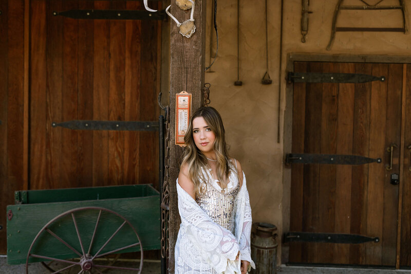 Girl posing for senior photo in stable
