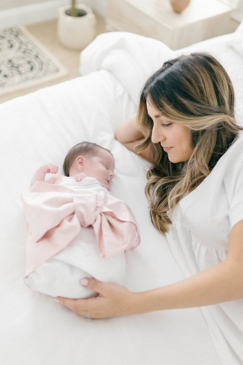 Mom laying in bed with newborn girl