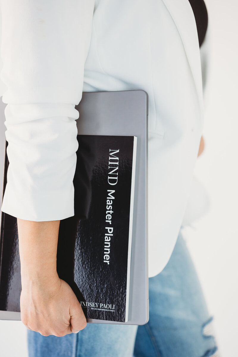 Business woman holding a black planner called MIND Master Planner