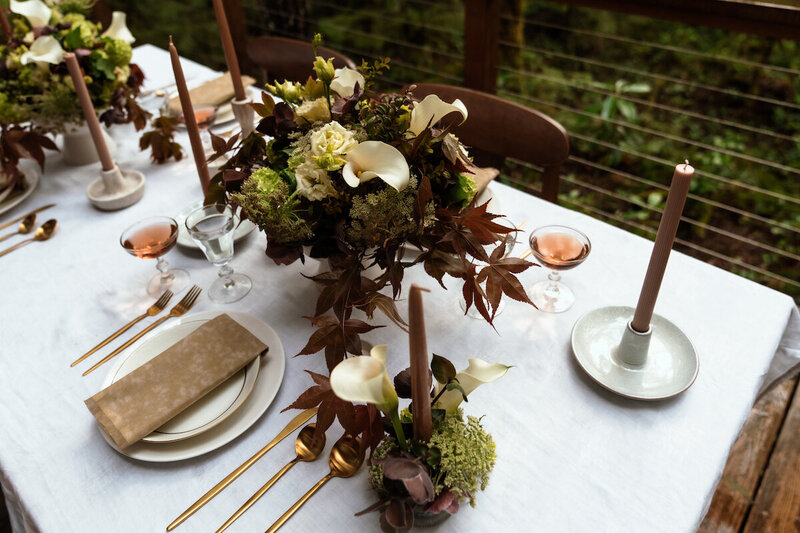 Table setup for intimate wedding dinner in Portland, Oregon. Local florals, candles, wine, gold silverware, linen napkins