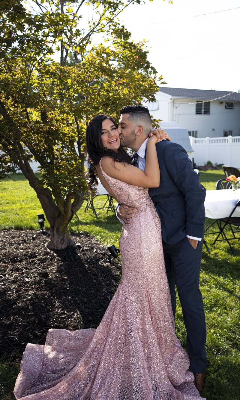 Photo of a man kissing his fiancee at a pre-wedding party
