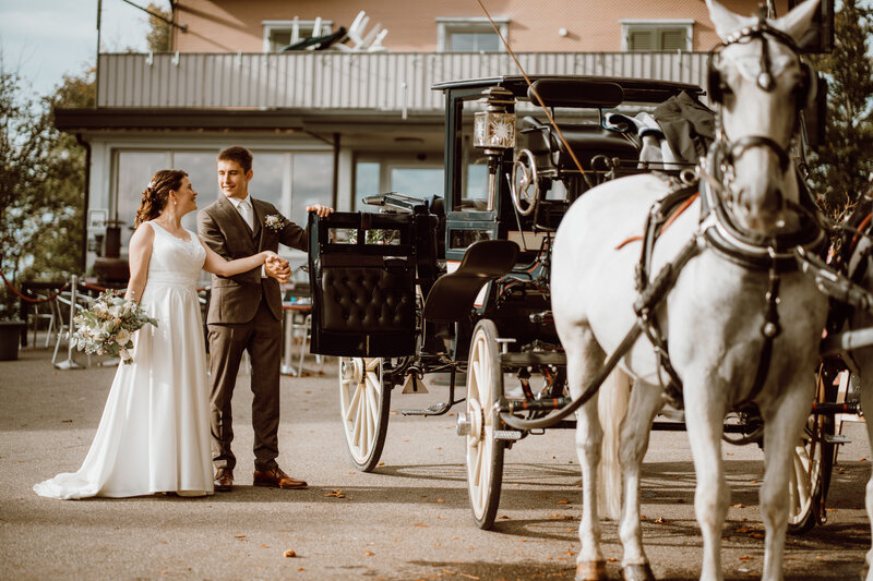 Ein magischer Augenblick, in dem der Bräutigam die Kutschentür für seine strahlende Braut öffnet, eine Szene voller Romantik und Eleganz von Kutschenfahrten Scherrer.