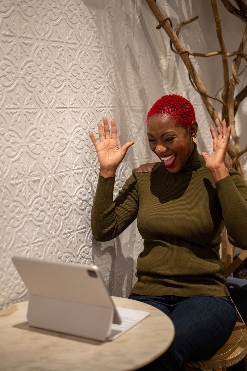 Nikisha King happily looking in her laptop while helping a client