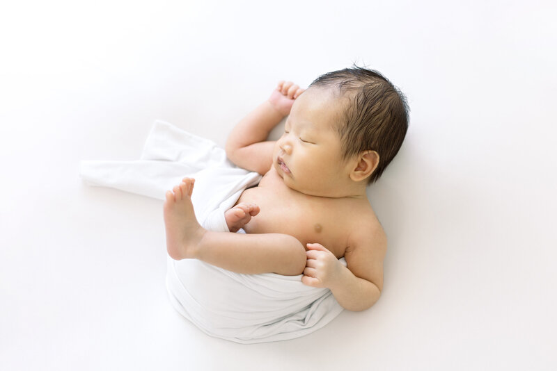 half swaddled newborn sleeping