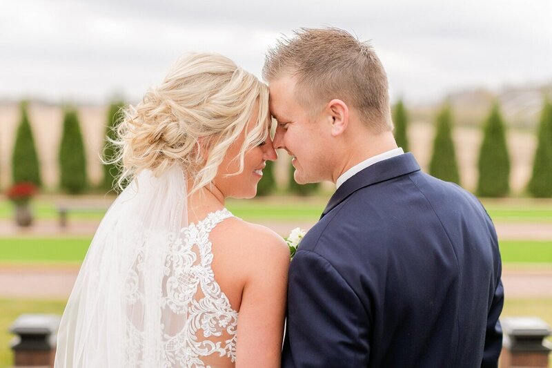 Bride and groom touching foreheads in front of row of trees, taken by wedding photographers st paul mn, Kacey Wyrick Photography