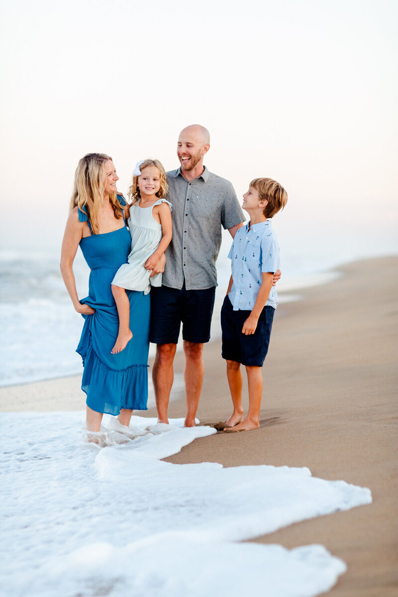 Authentic, heartfelt motherhood session with Brooke Tucker capturing a mom laughing with her children along the beach in Coastal Virgnia