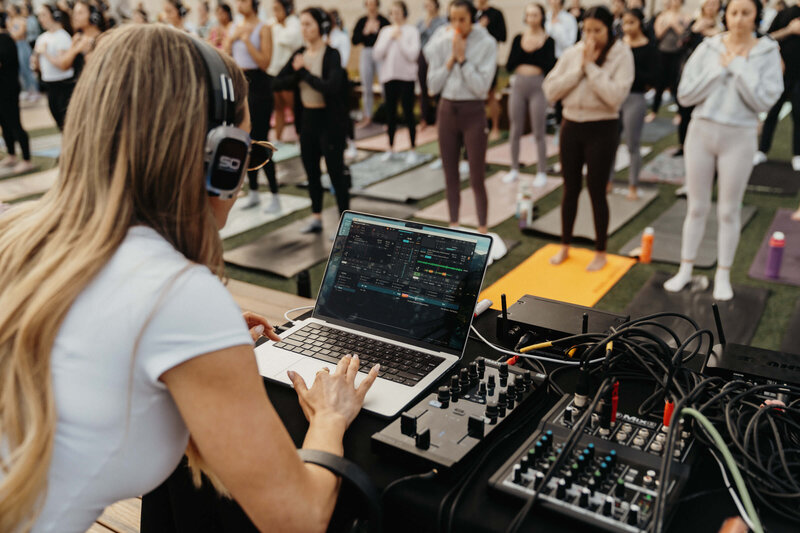 female dj playing music during a yoga flow set
